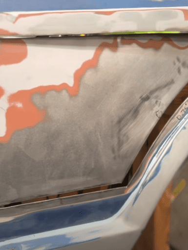 Car bodywork repair in progress, features rust removal and patch panel fitting with measurements marked in inches.