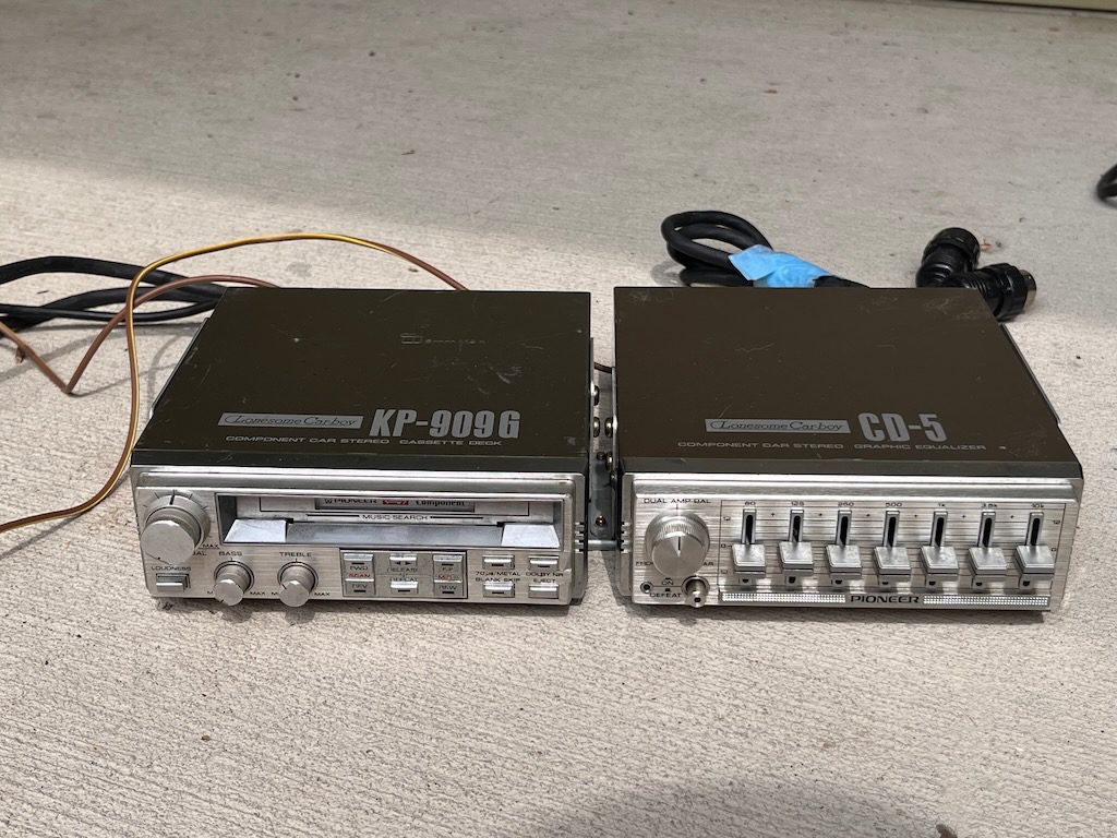 Vintage Pioneer KP-909G cassette deck and CD-5 graphic equalizer car stereo components on a beige background.