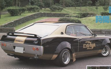 Vintage customized Eizo car with Ultra and E.YAZAWA decals parked in a green park with stone wall.