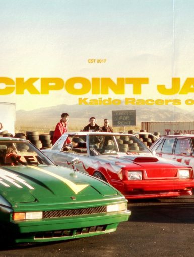 Custom Japanese sports cars and racers at Checkpoint Japan event in California with mountain backdrop.