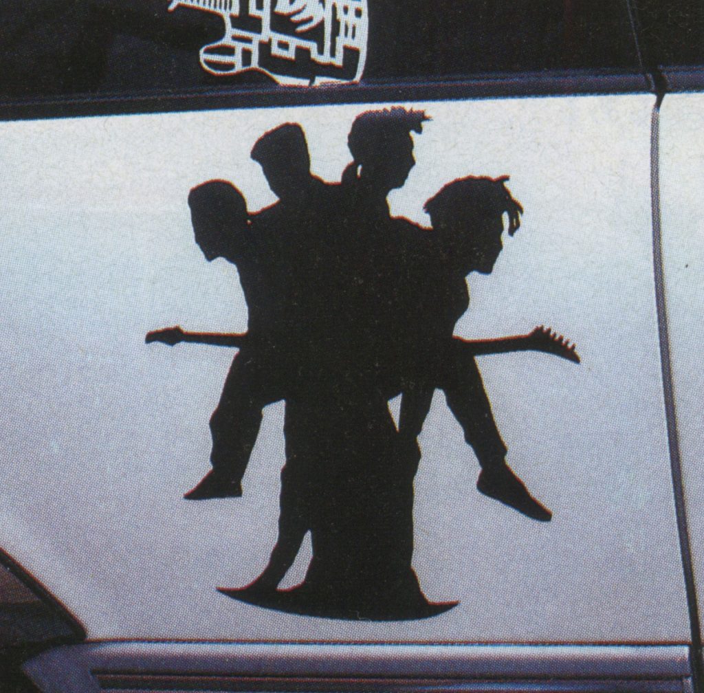 Silhouette band decal on car door with guitar on headstock labeled 東京 meaning Tokyo.