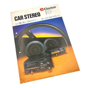 Vintage Clarion car stereo advertisement featuring speakers and cassette player. Japanese text translates to Resonating beautiful sound.