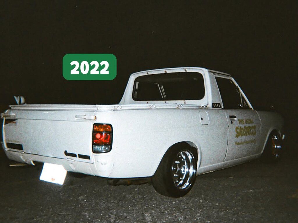 Retro white pickup truck at night, rear view with 2022 label, stylish vintage vibe.