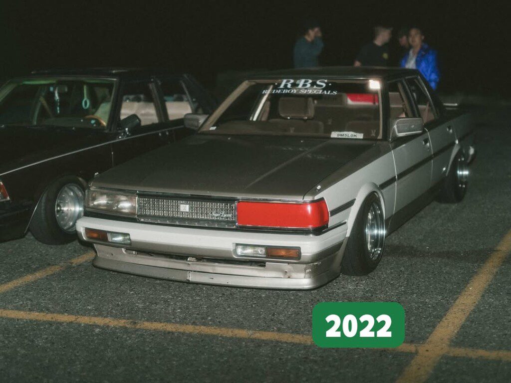 Lowered vintage car with custom wheels at a night car meet, 2022 edition.