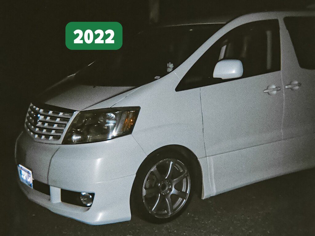 White minivan with sleek design, captured at night, with 2022 label indicating model year.