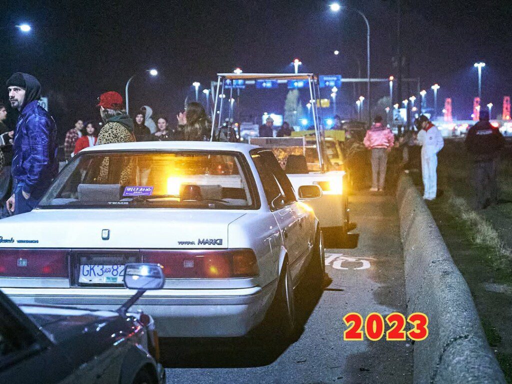 Street gathering with classic Toyota Mark II cars, nighttime scene, 2023.
