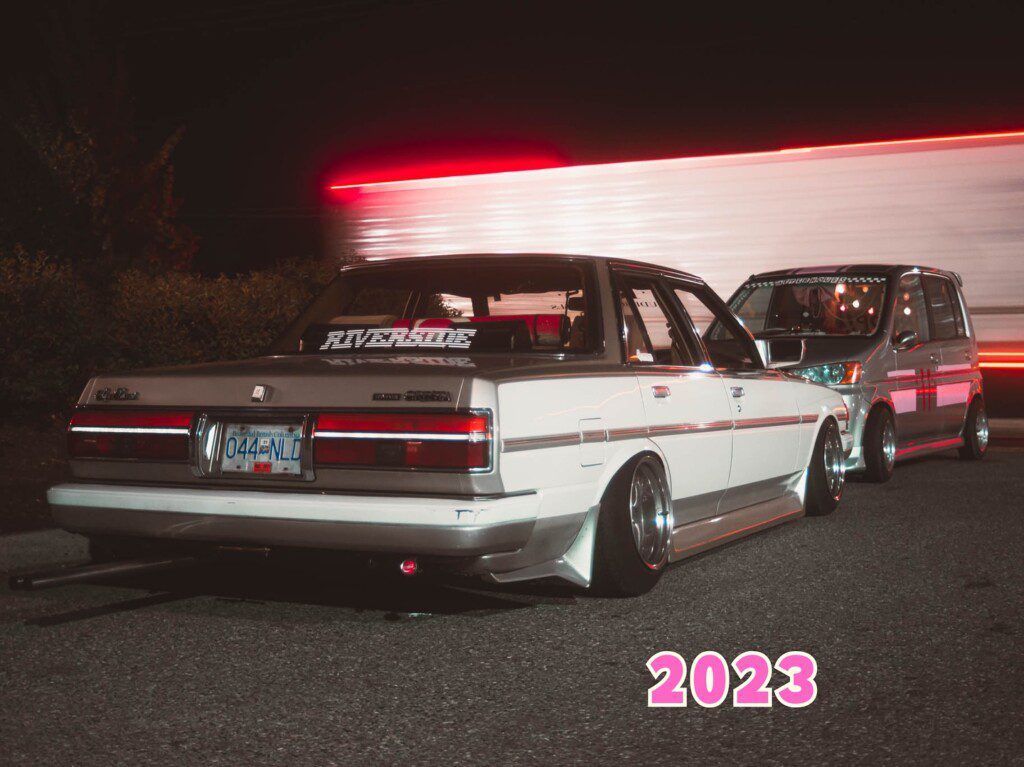 Modified vintage cars at night with neon lights, 2023.