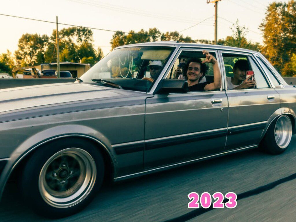 Group enjoying a ride in vintage car on a sunny day, 2023. Classic vehicle with friends sharing smiles and memories.