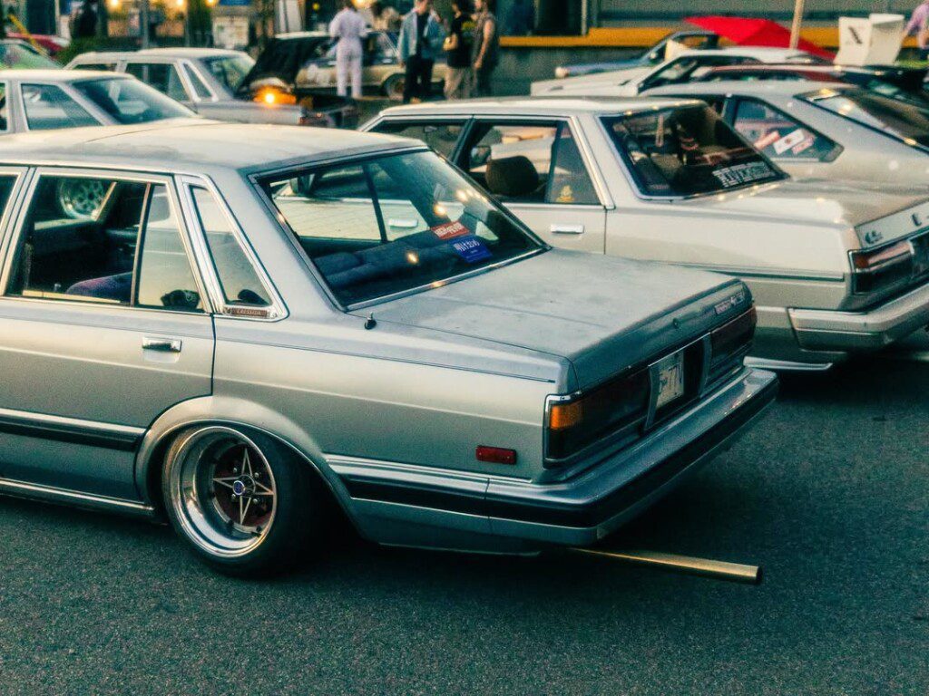 Vintage classic cars in a parking lot, showcasing retro style and automotive culture at an outdoor car meet.