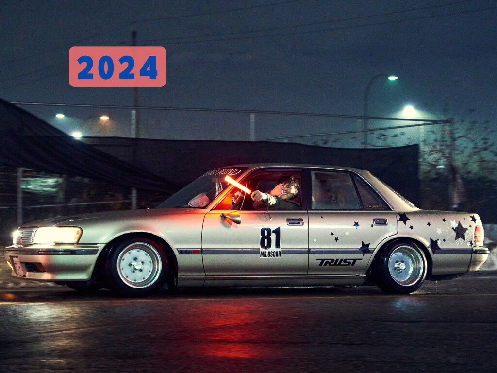Vintage car with star decals and number 81 driving at night, glowing sword adds intrigue. Text: 2024.
