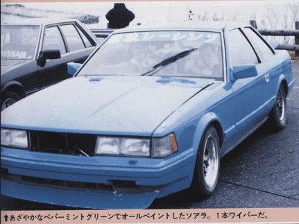 Vintage blue Toyota Soarer parked outdoors with racing decals, showcasing classic Japanese automotive style.