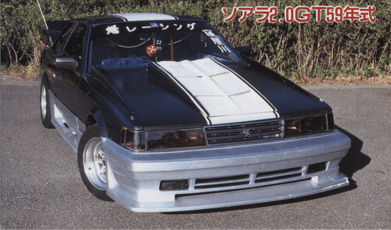 Customized black Toyota Soarer 2.0GT with a white hood and front aerodynamics parked on a sunny day.