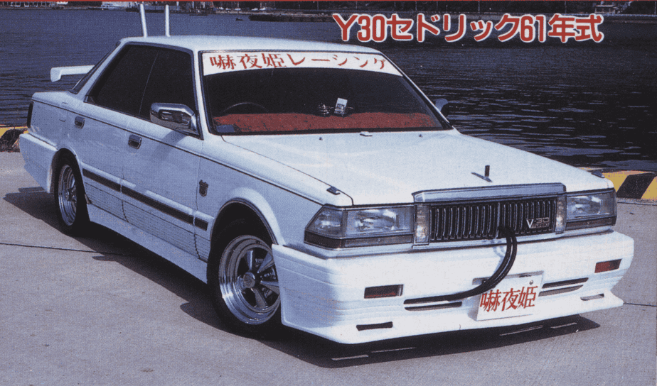 Customized white Nissan Cedric Y30 parked by the waterfront with unique modifications and Japanese text.