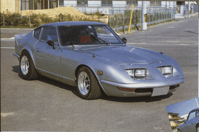 Vintage gray sports car parked on a sunny street, showcasing a classic design and sleek curves.