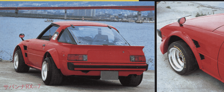 Vintage red sports car parked by the water with customized wide wheels and flared fenders.
