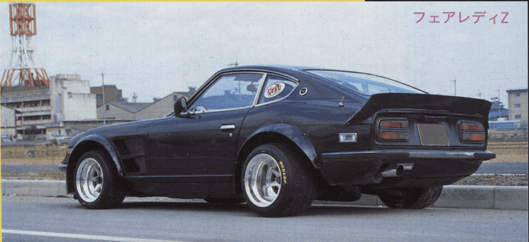 Vintage black sports car parked on street, showcasing modified design and sleek curves.