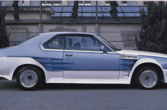 Side view of a custom retro car with sporty body kit, parked on a street with trees in the background.